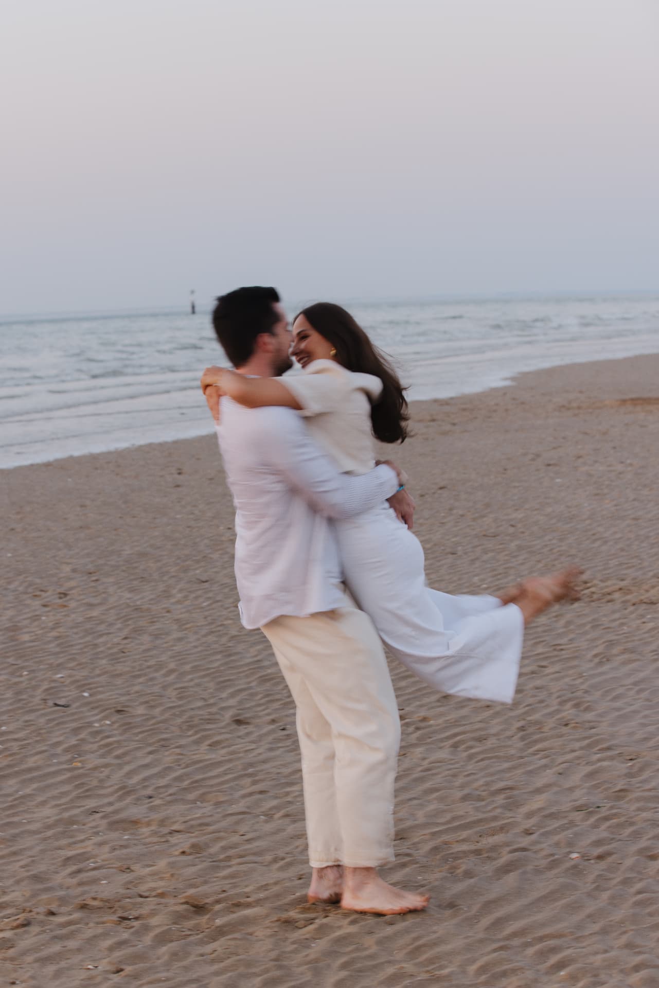 Juliette et Alexandre enlacés sur la plage au coucher du soleil
