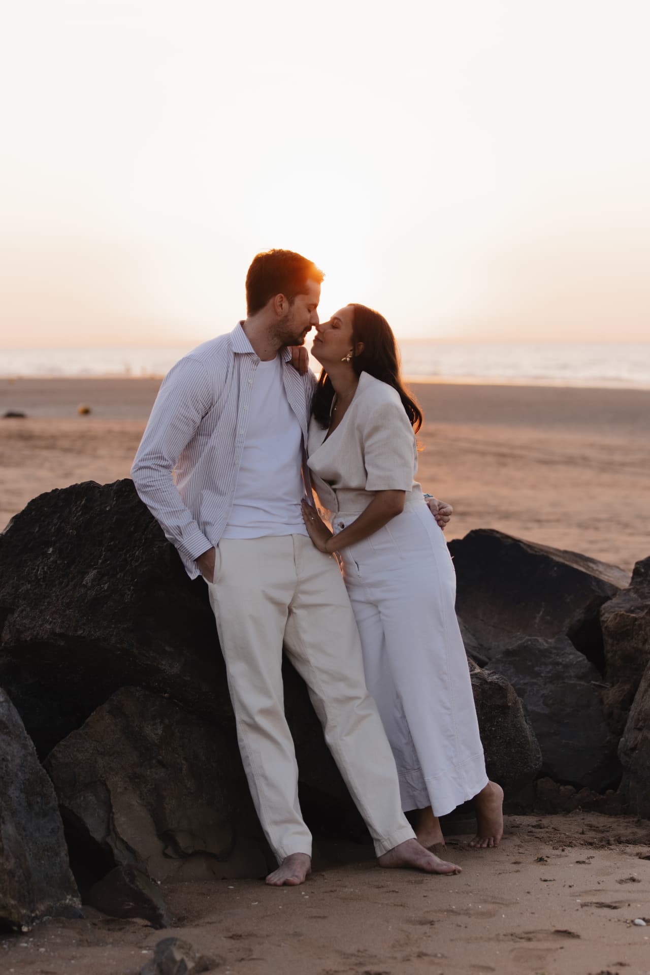 Juliette et Alexandre s'embrassant contre les rochers sur la plage