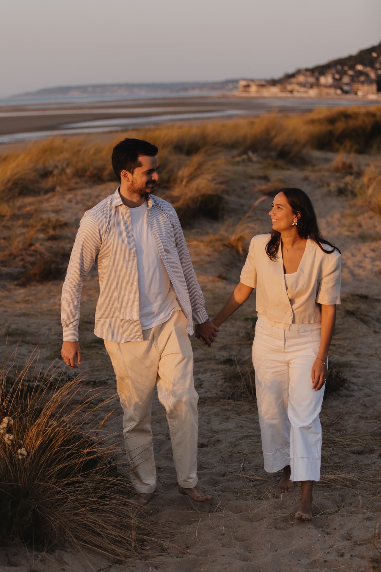 Juliette et Alexandre marchant main dans la main sur la plage au coucher du soleil